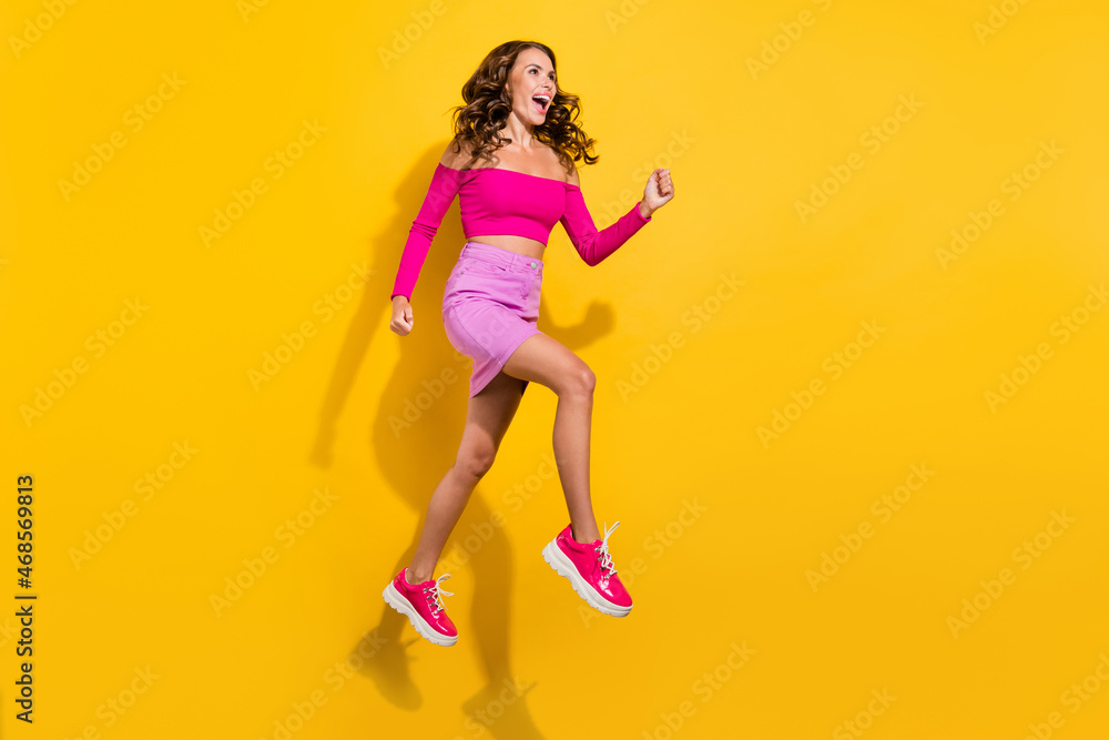 Full length body size view of lovely cheerful girl jumping runnig having fun isolated over bright yellow color background