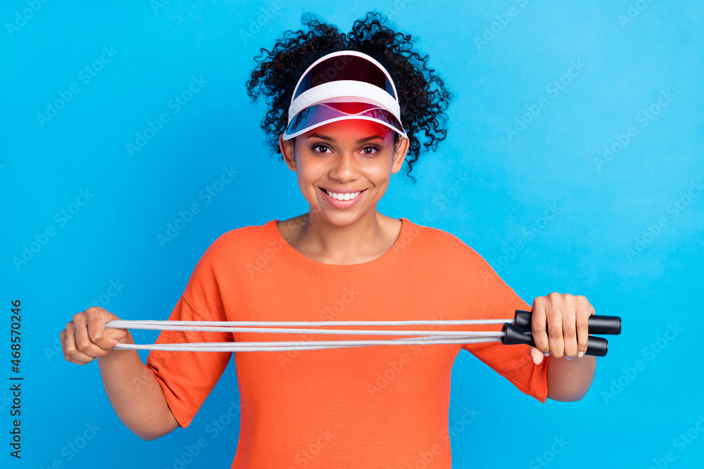 Photo of young african woman happy positive smile hold jump-rope sporty exercise weight loss isolated over blue color background Photo of young african woman happy positive smile hold jump-rope sporty exercise weight loss isolated over blue color background
