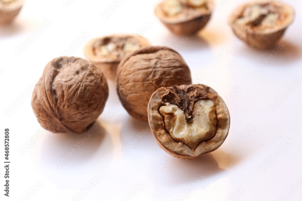 Whole and cracked walnuts on white background, selective focus Whole and cracked walnuts on white background, selective focus