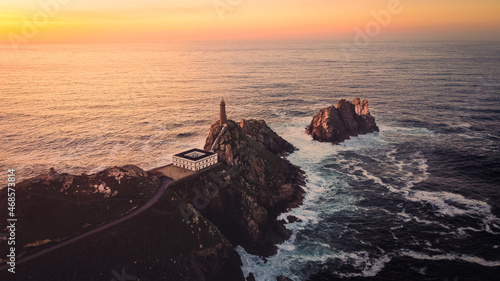 Cape Finisterre Lighthouse the end of the earth famous tourist destination in Galicia northern Spain region, aerial drone footage at sunset photo