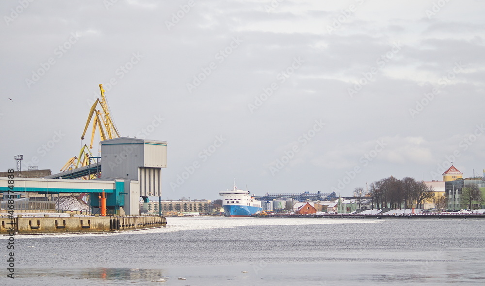View of Ventspils port, river Venta, ship, cranes and castle, Ventspils, Latvia.