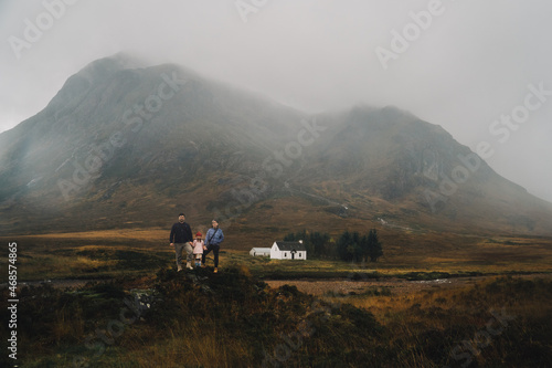 Early morning photo of the family, standing in the front of the foggy Scottish landscape.