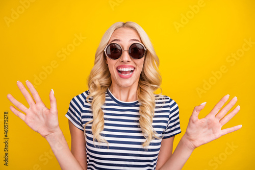 Portrait of attractive cheerful amazed girl having fun shopping sale news isolated over vibrant yellow color background