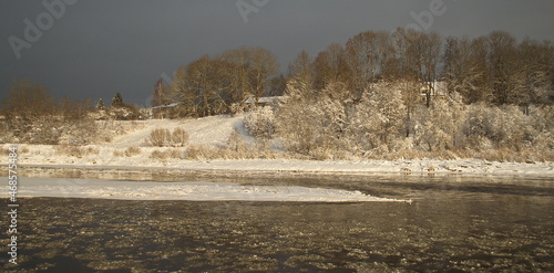 River Venta and snowy shore on a sunny winter day, Kuldiga, Latvia.