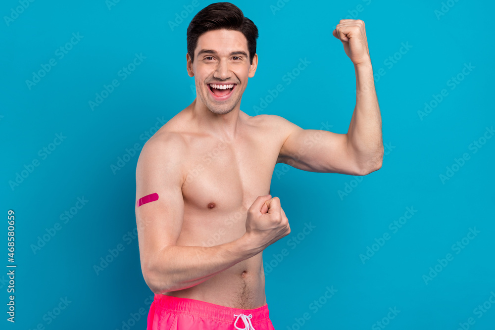 Fototapeta premium Photo of glad vaccinated guy celebrate victory raise fists hand plaster wear shorts isolated blue color background