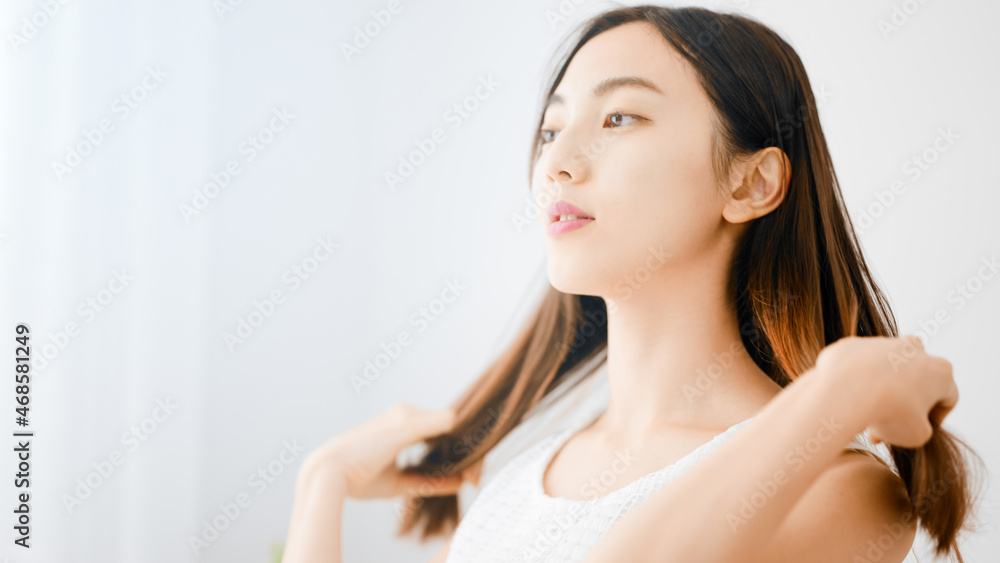 ヘアケアをする若い女性 ヘアケアをする若い女性