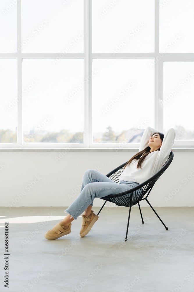 Happy pretty woman lying in the armchair on the weekend. Happy pretty woman lying in the armchair on the weekend.