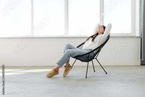 Happy young woman relaxing in chair at home