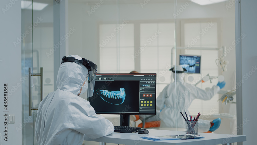 Orthodontists analyzing virtual teeth animation at oral clinic desk. Professional assistant looking at scan on computer monitor while dentist examining model for patient implant - obrazy, fototapety, plakaty 