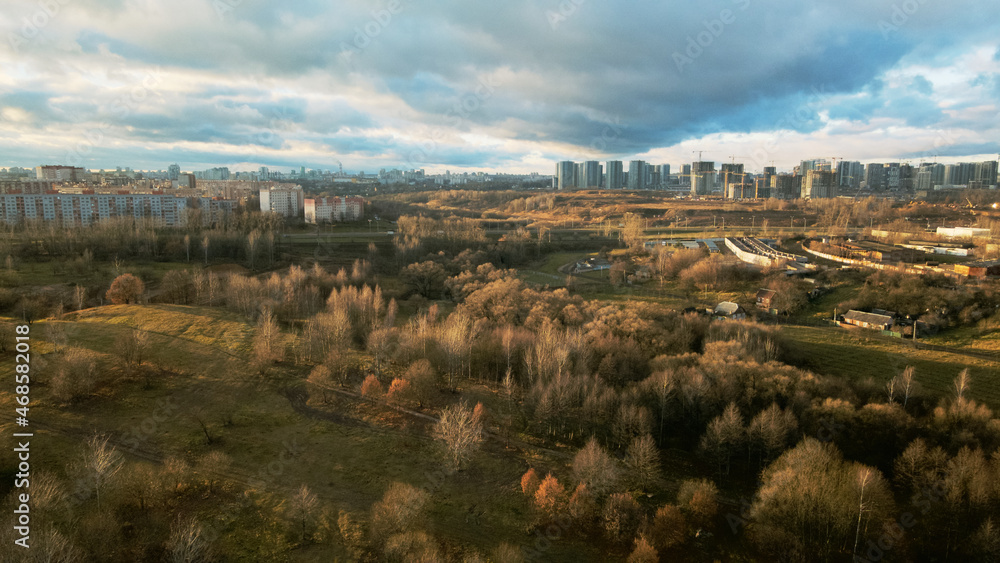 Flight over city blocks. There is a park area nearby. Flying in the backlight of the setting sun. Aerial photography. Flight over city blocks. There is a park area nearby. Flying in the backlight of the setting sun. Aerial photography.