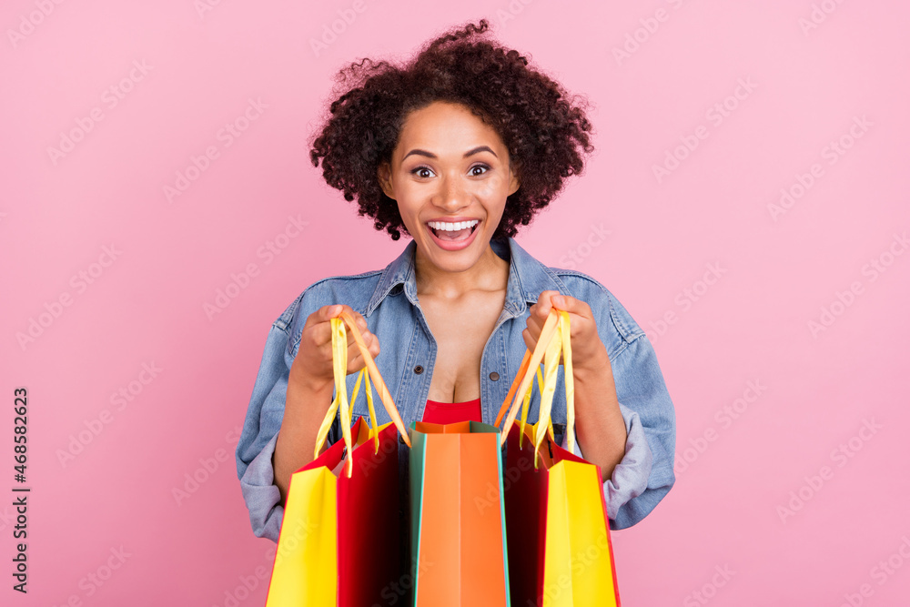Photo of young happy cheerful afro american amazed woman hold hands sale bags isolated on pink color background Photo of young happy cheerful afro american amazed woman hold hands sale bags isolated on pink color background