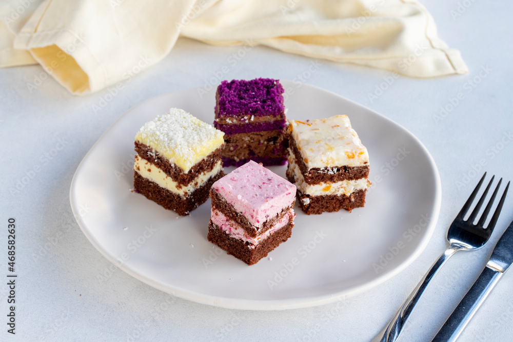 Mini cake desserts in different flavors. Delicious cakes on a white background Mini cake desserts in different flavors. Delicious cakes on a white background