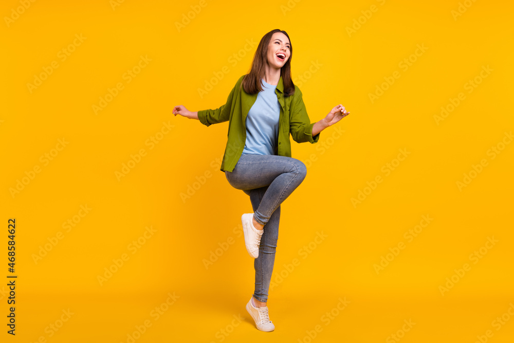 Photo of sweet adorable young woman dressed green shirt dancing smiling isolated yellow color background Photo of sweet adorable young woman dressed green shirt dancing smiling isolated yellow color background