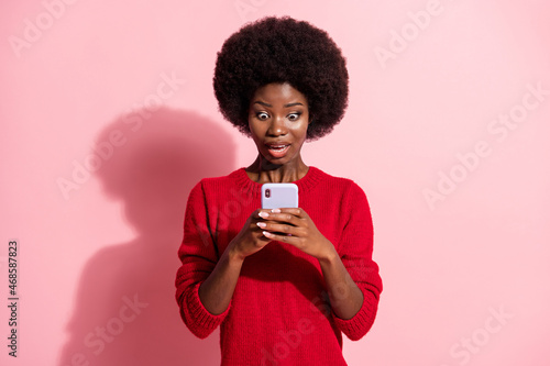 Photo of impressed pretty dark skin person open mouth staring phone isolated on pink color background