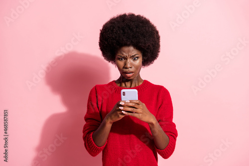 Portrait of attractive nervous outraged girl using device bad news media dislike isolated over pink pastel color background
