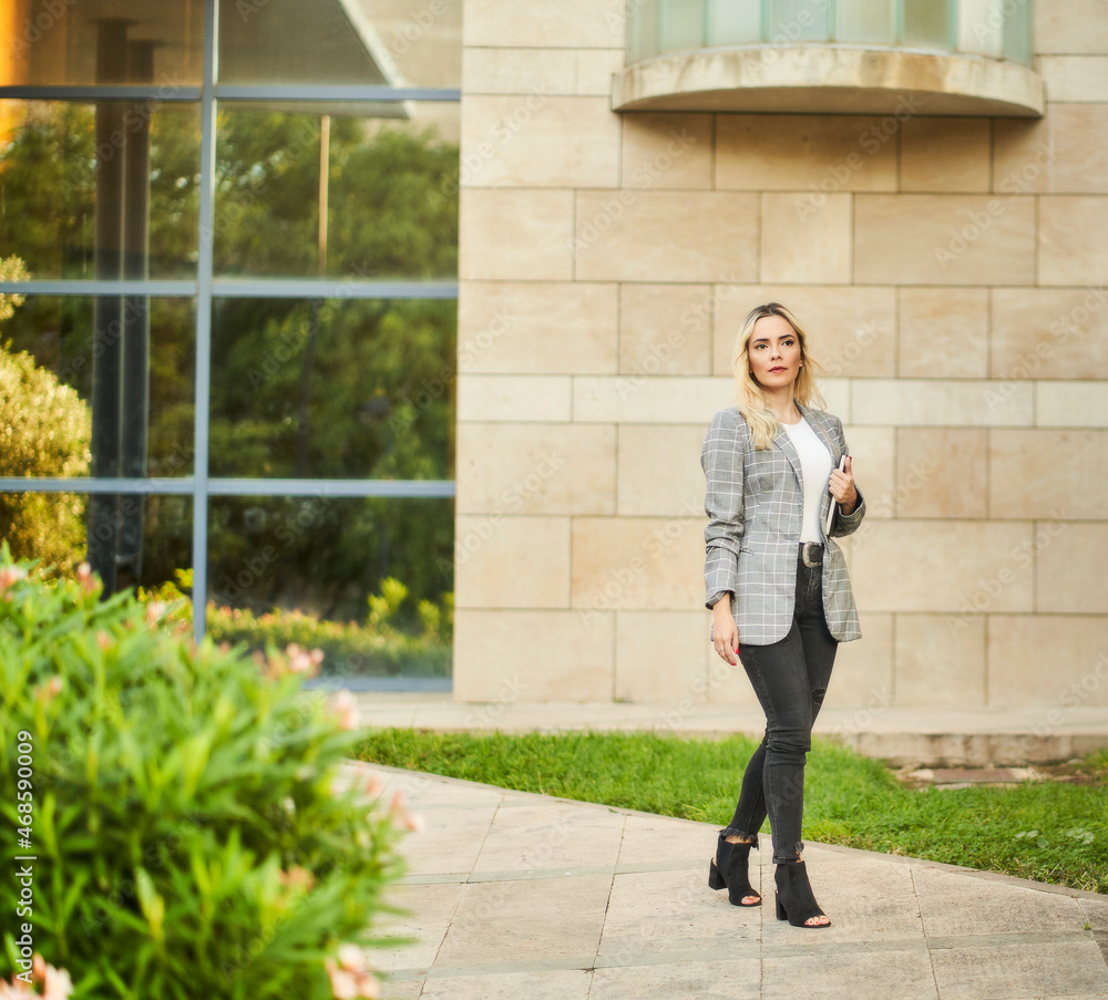 young businesswoman walking out of office with agenda in hand