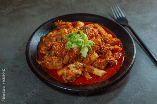 Korean food Spicy Stir-fried Chicken tteokbokki dish on black plate photo