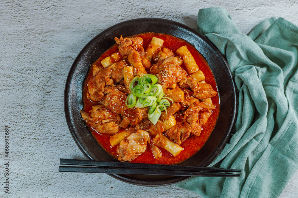 Korean food Spicy Stir-fried Chicken tteokbokki dish on black plate Korean food Spicy Stir-fried Chicken tteokbokki dish on black plate