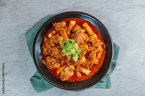 Korean food Spicy Stir-fried Chicken tteokbokki dish on black plate photo