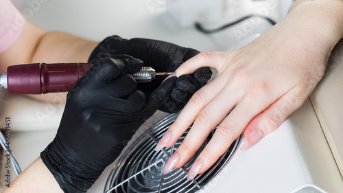  Hardware manicure. Manicure process  cuticle removal with a cutter. Processing nails with an electric file.