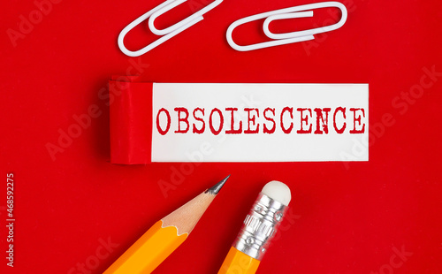 Tableau sur toile OBSOLESCENCE message written on torn red paper with pencils and clips, business