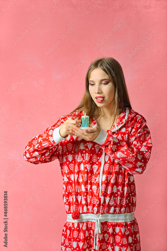 New Year's portrait of a beautiful girl in red pajamas. pink background New Year's portrait of a beautiful girl in red pajamas. pink background