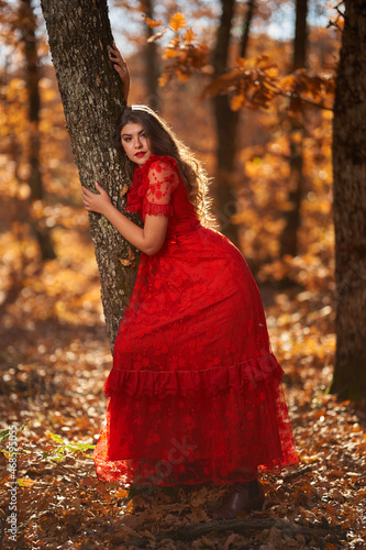 Woman in red dress in the oak forest, full body