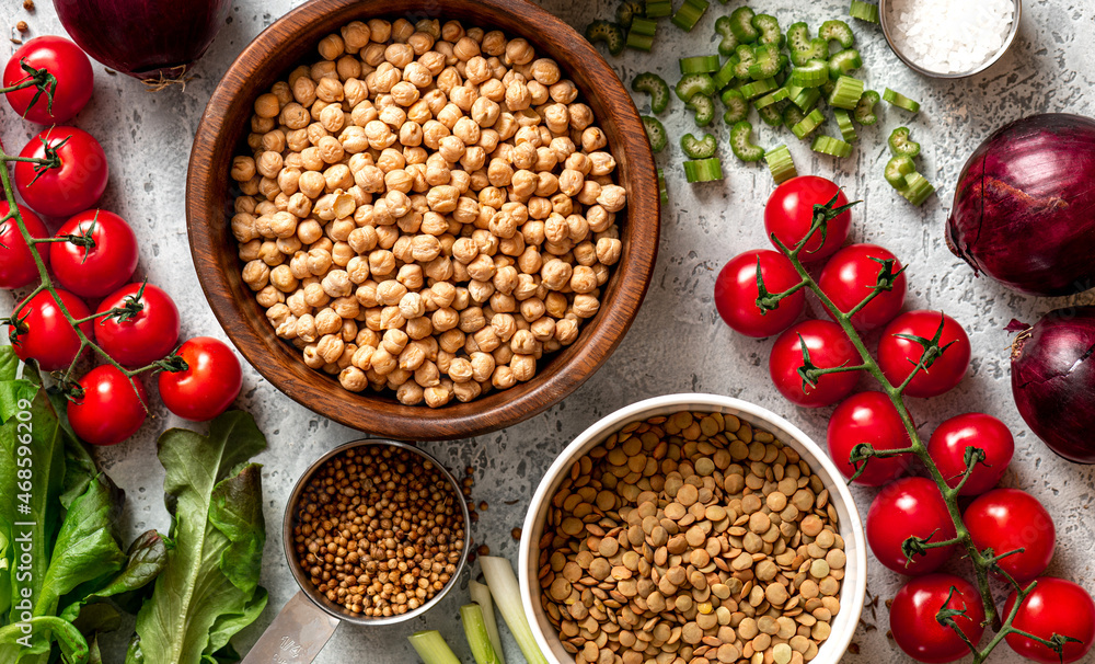 Various vegetables, spices and chickpeas on a gray concrete background top view. Vegan food, healthy eating concept. Food background. Cooking food. Various vegetables, spices and chickpeas on a gray concrete background top view. Vegan food, healthy eating concept. Food background. Cooking food.