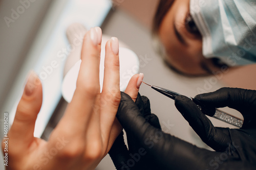 Manicure process female hands finger nails polish.