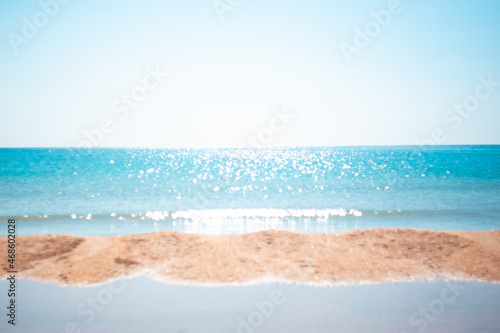 Fototapeta Naklejka Na Ścianę i Meble -  Defocused landscape.Beautiful sparkling sea with a strip of sandy shore, blurred focus. Natural background for text. Travel and tourism