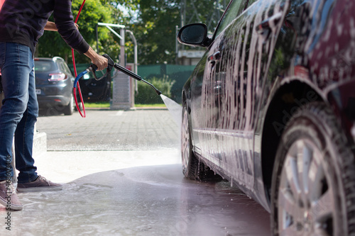 random guy washing the car in the self service car wash station