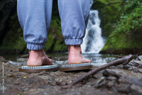 Sadhu boards in nature. Therapy of standing on nails on the background of a waterfall