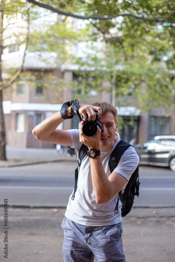Young man with digital SLR camera take pictures on the city street Young man with digital SLR camera take pictures on the city street
