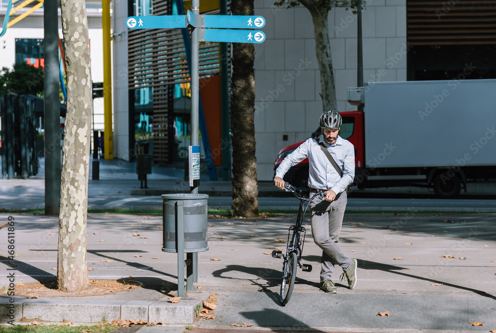 Serious businessman with bicycle crossing road on zebra Serious businessman with bicycle crossing road on zebra