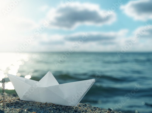 White paper boat near river on sunny day
