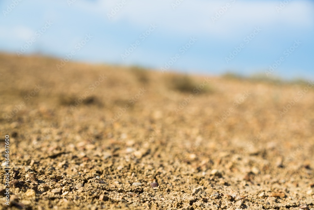 The dry ground is cracked and blue sky