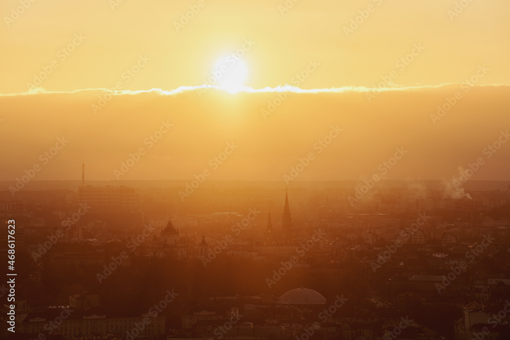 Bright orange sunset over the city with building silhouette. Lviv, Ukraine.