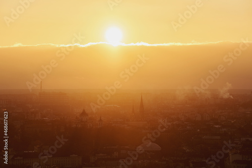 Bright orange sunset over the city with building silhouette. Lviv, Ukraine.