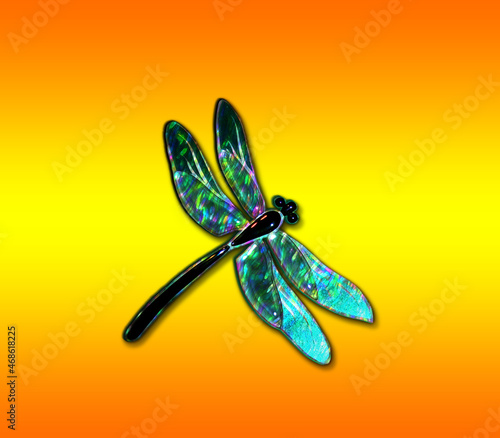 Beautiful glass dragonfly with effect of holography on a bright orange background