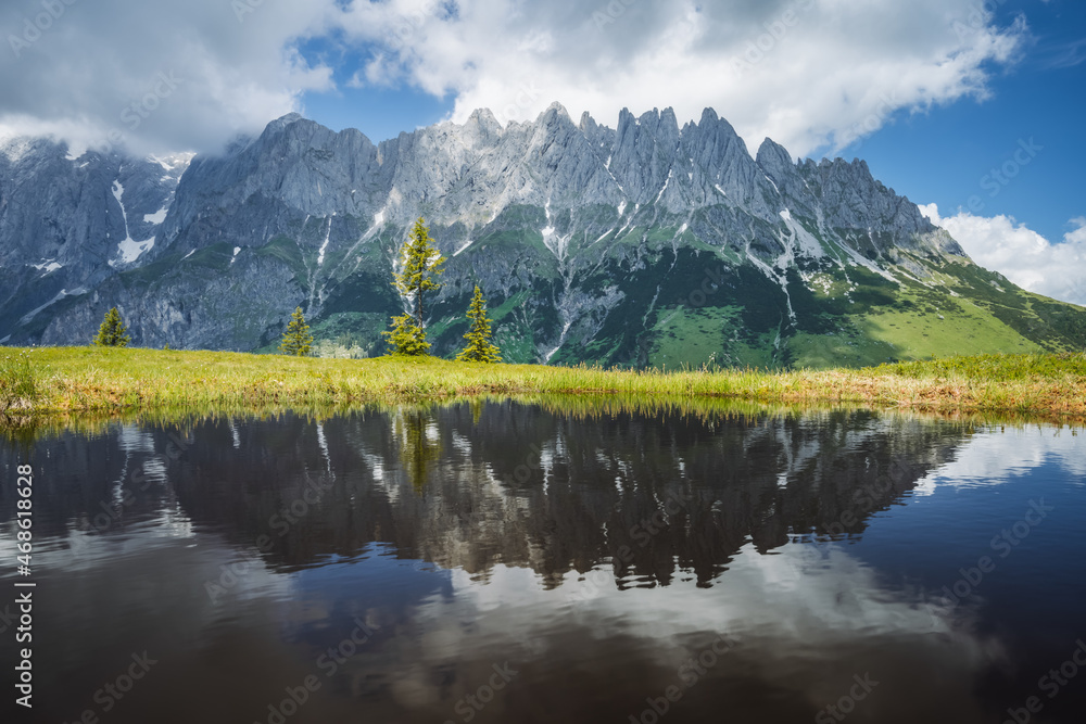 Mountain pond with Wilder Kaiser range reflecting in water pond, Tirol - Austria
