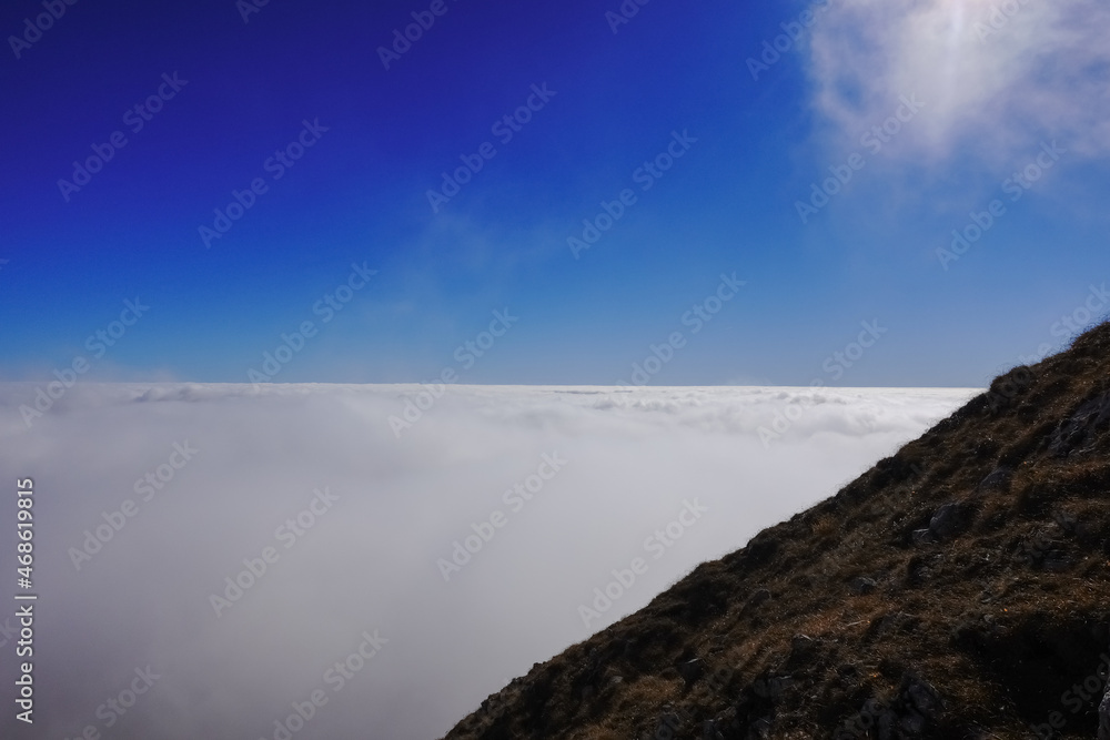 dense white fog at the horizon with blue sky while hiking