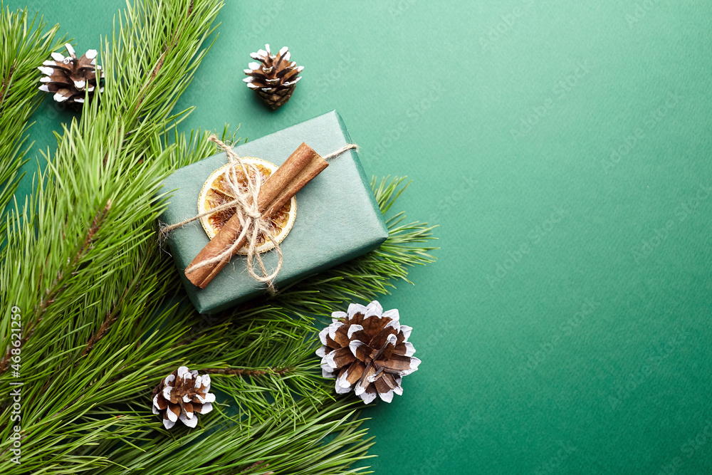 Christmas gift box and pine tree branches with decoration on green