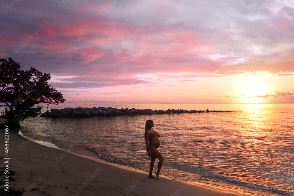 person walking on the beach at sunrise