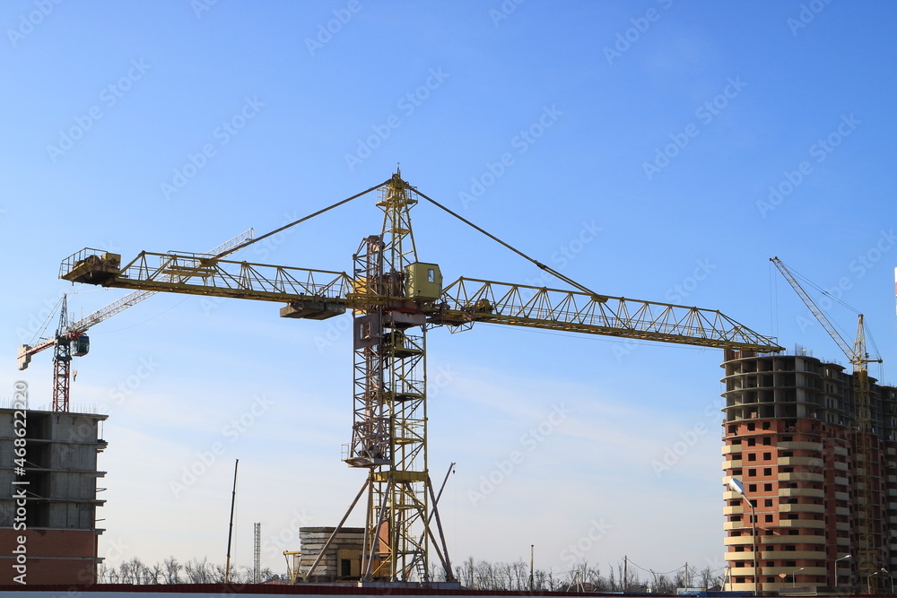 Tower cranes are working on the construction of a new house. Lifting crane.