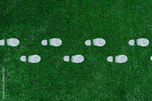 White boot prints on the green grass.Football field