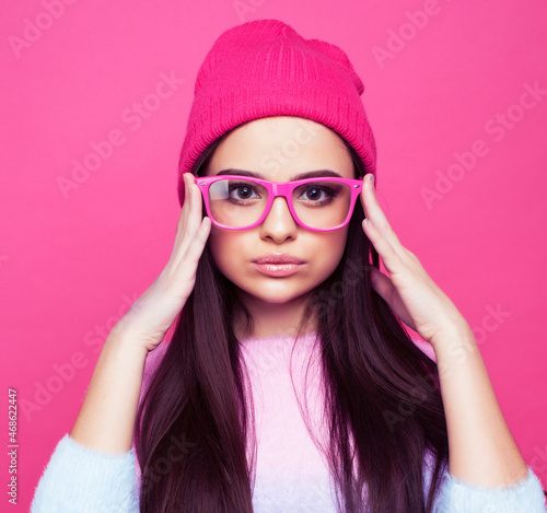 young pretty girl with brunette long hair posing cheerful on pink background, lifestyle people concept