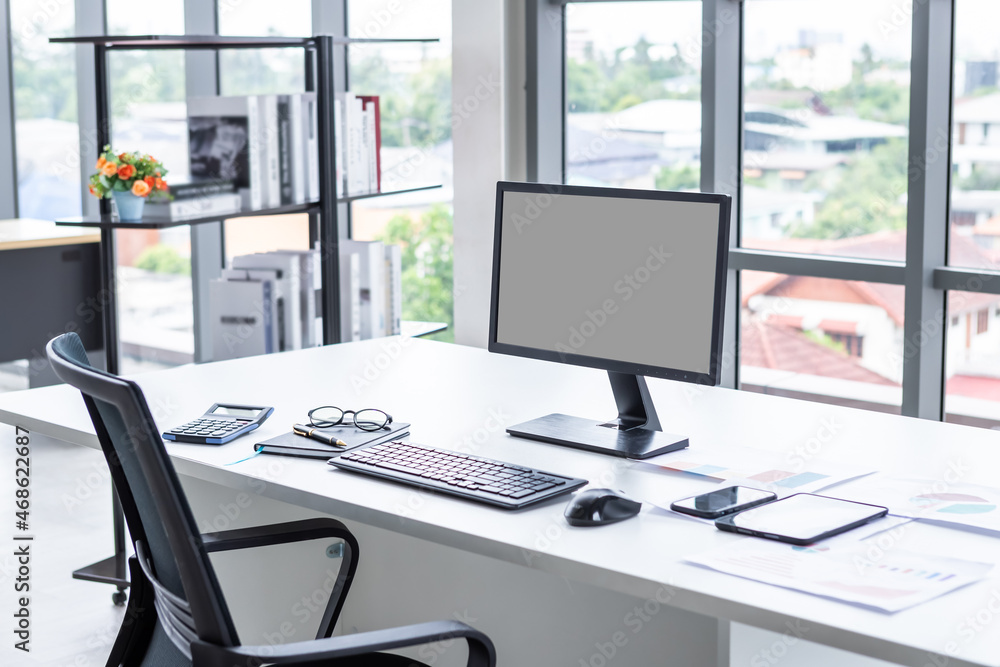 Workspace Business mockup desktop computer empty black gray screen with keyboard notebook and other accessories on Modern dark wooden office corner and black office chairs with window in office Workspace Business mockup desktop computer empty black gray screen with keyboard notebook and other accessories on Modern dark wooden office corner and black office chairs with window in office