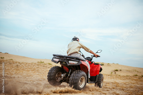 An atv rider racing in desert photo