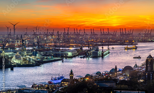 The beautiful harbour of Hamburg from above with luxury super-yacht in the dock and cranes on the horizon during sunset