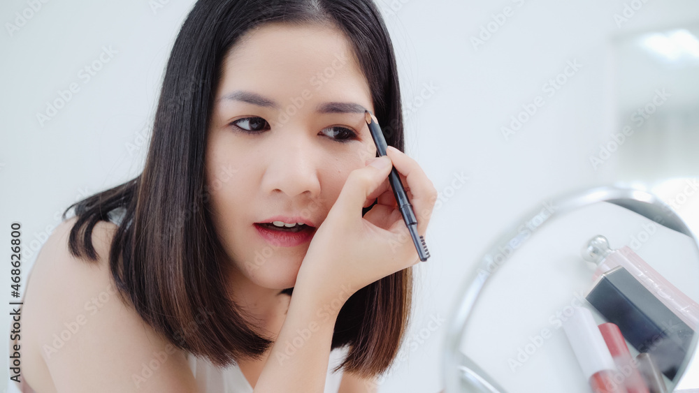 Beauty blogger present beauty cosmetics sitting in front camera for recording video. Happy beautiful young Asian woman use cosmetics review make up tutorial broadcast live video to social network. Beauty blogger present beauty cosmetics sitting in front camera for recording video. Happy beautiful young Asian woman use cosmetics review make up tutorial broadcast live video to social network.